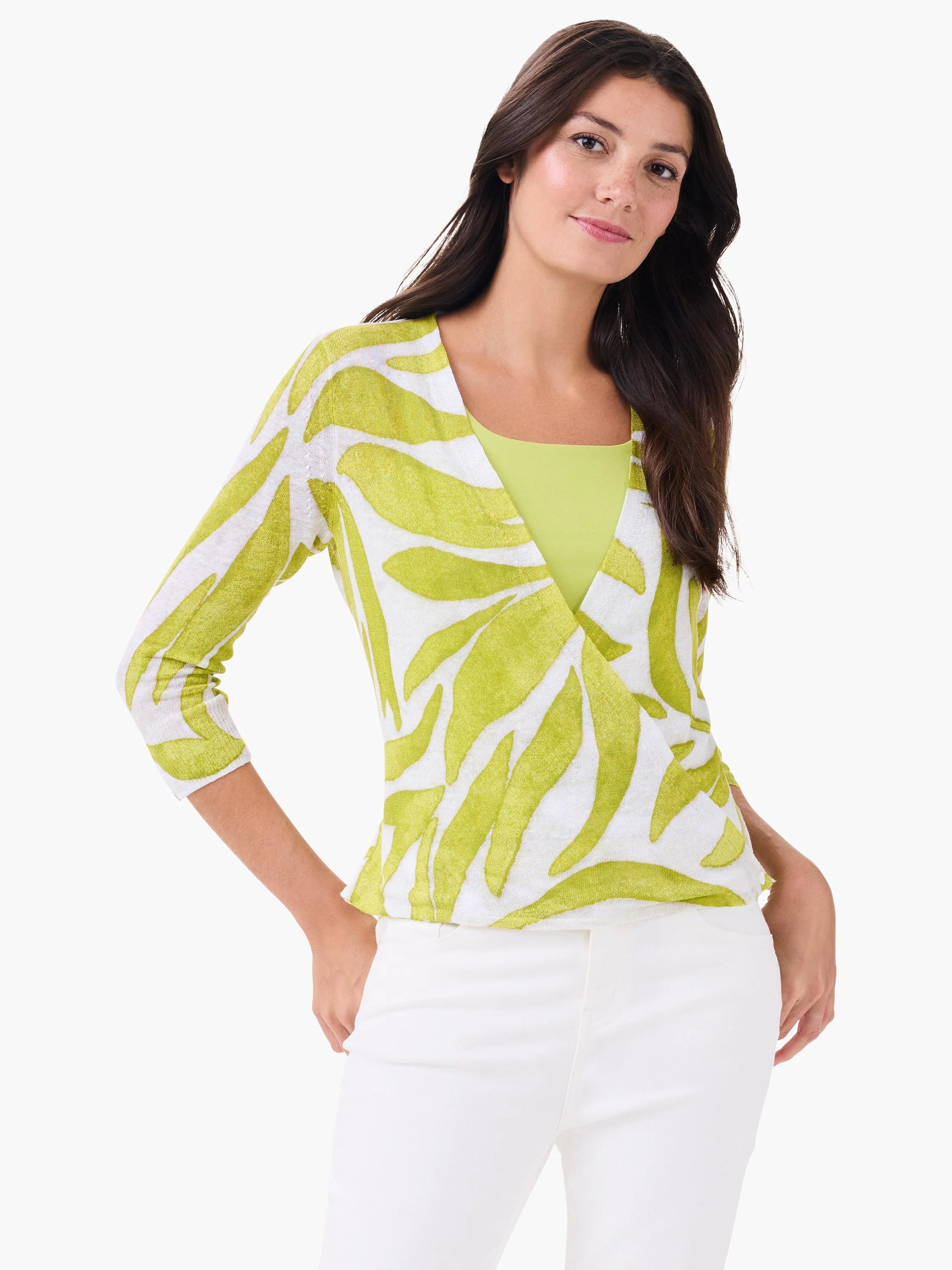 White V-neck cardigan with 3/4 sleeves and a lime green leaf pattern, worn open over a solid green top.