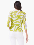 White cardigan with light green abstract leaf pattern and 3/4 sleeves, shown from the back.