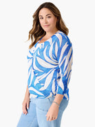Blue & white swirling pattern cardigan, worn as a V-neck wrap top with 3/4 sleeves. Single blue button detail.