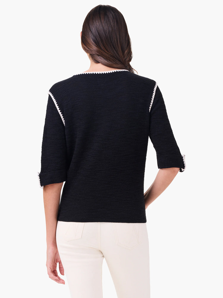 Textured black sweater with white scalloped trim on neckline, shoulders, and 3/4 sleeves.