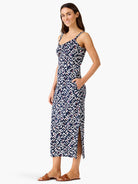 Indigo midi slip dress with white, pink, orange angular pattern, pockets, and side slit.