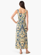 Back view of a sleeveless maxi dress. Abstract pattern in navy, gold, beige, and teal, with a square back and gathered waist.