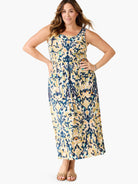 Sleeveless maxi dress with an abstract pattern in cream, navy, olive, and teal. Square neck, cinched waist.