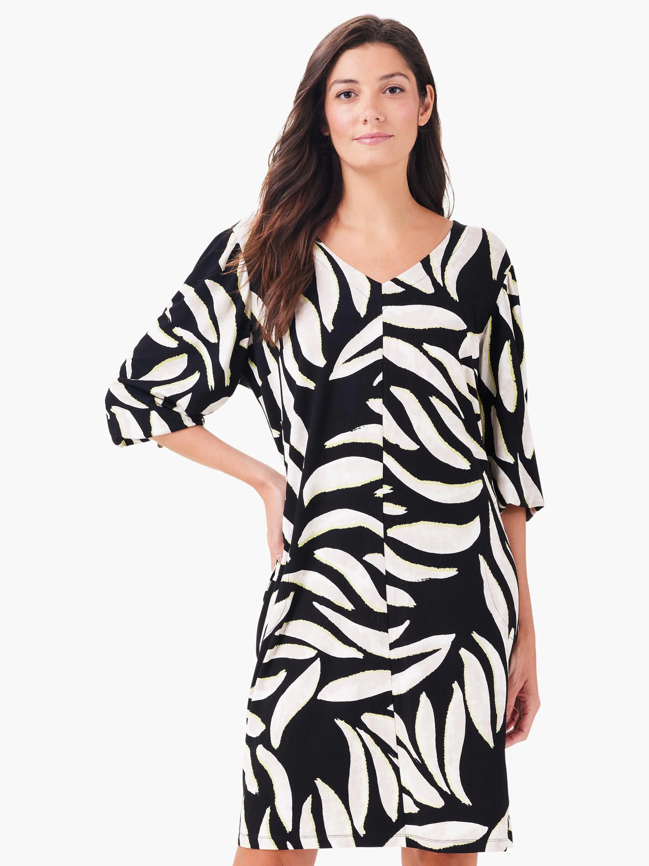 Black V-neck dress with 3/4 sleeves and a pattern of large off-white, leaf-like shapes subtly outlined in pale green.