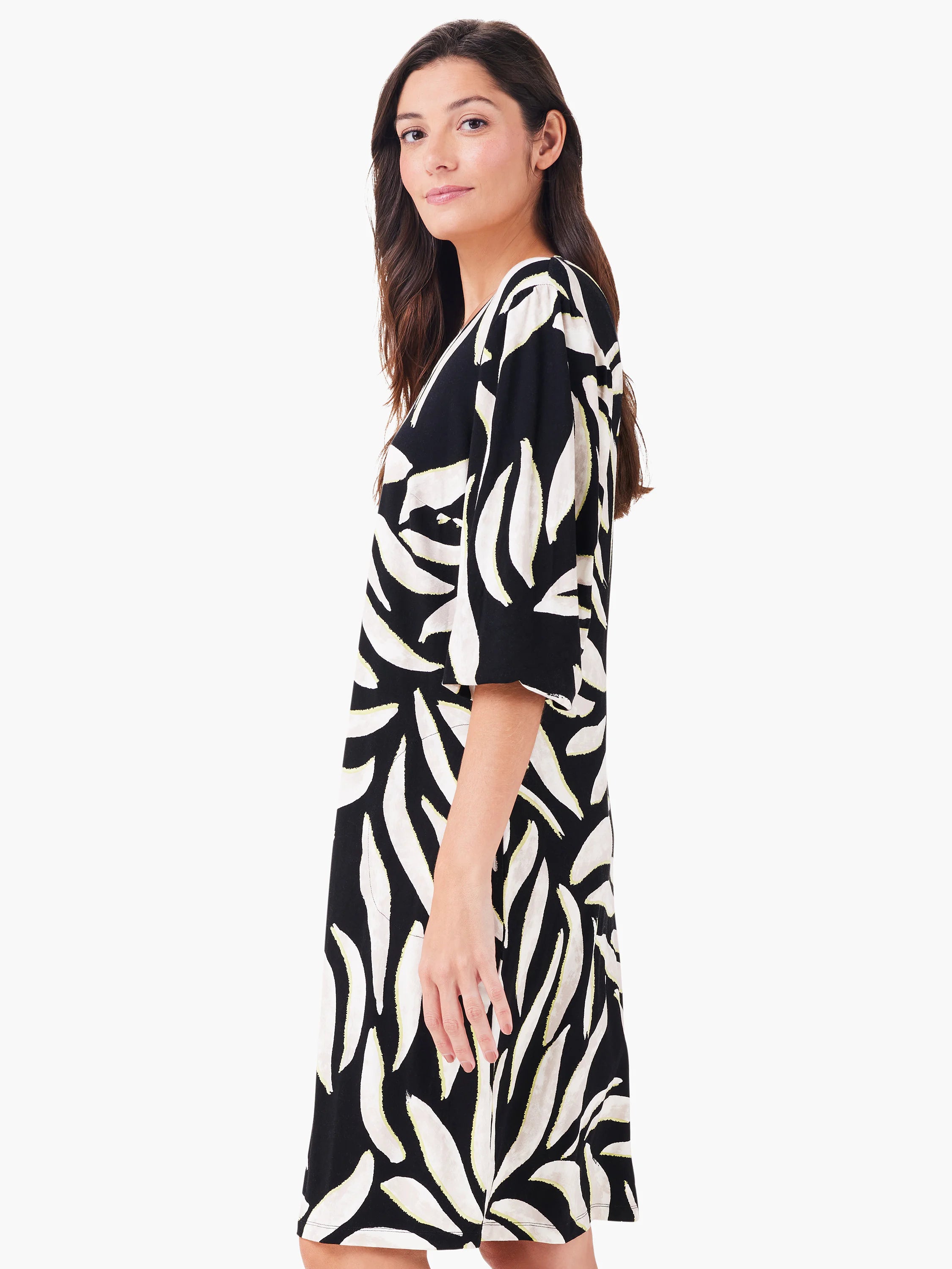 Black V-neck dress with off-white and yellow abstract leaf print. Relaxed fit, elbow sleeves, knee-length.