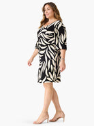 Black V-neck dress with abstract cream leaves and subtle green accents. Features 3/4 sleeves, knee-length, and pockets.