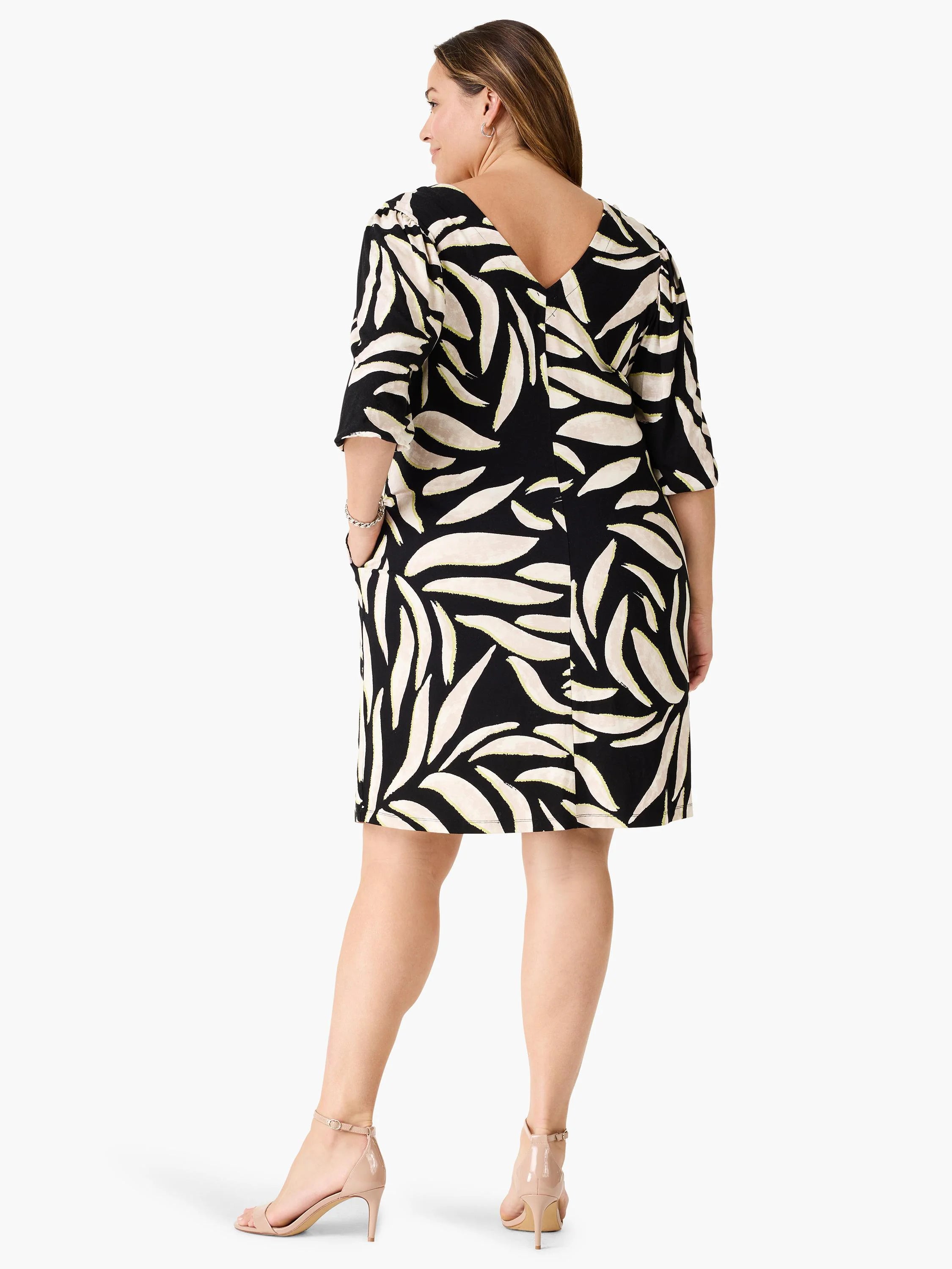 Black V-neck dress with 3/4 sleeves. Off-white abstract leaf pattern with faint yellow accents. Knee-length, pockets.