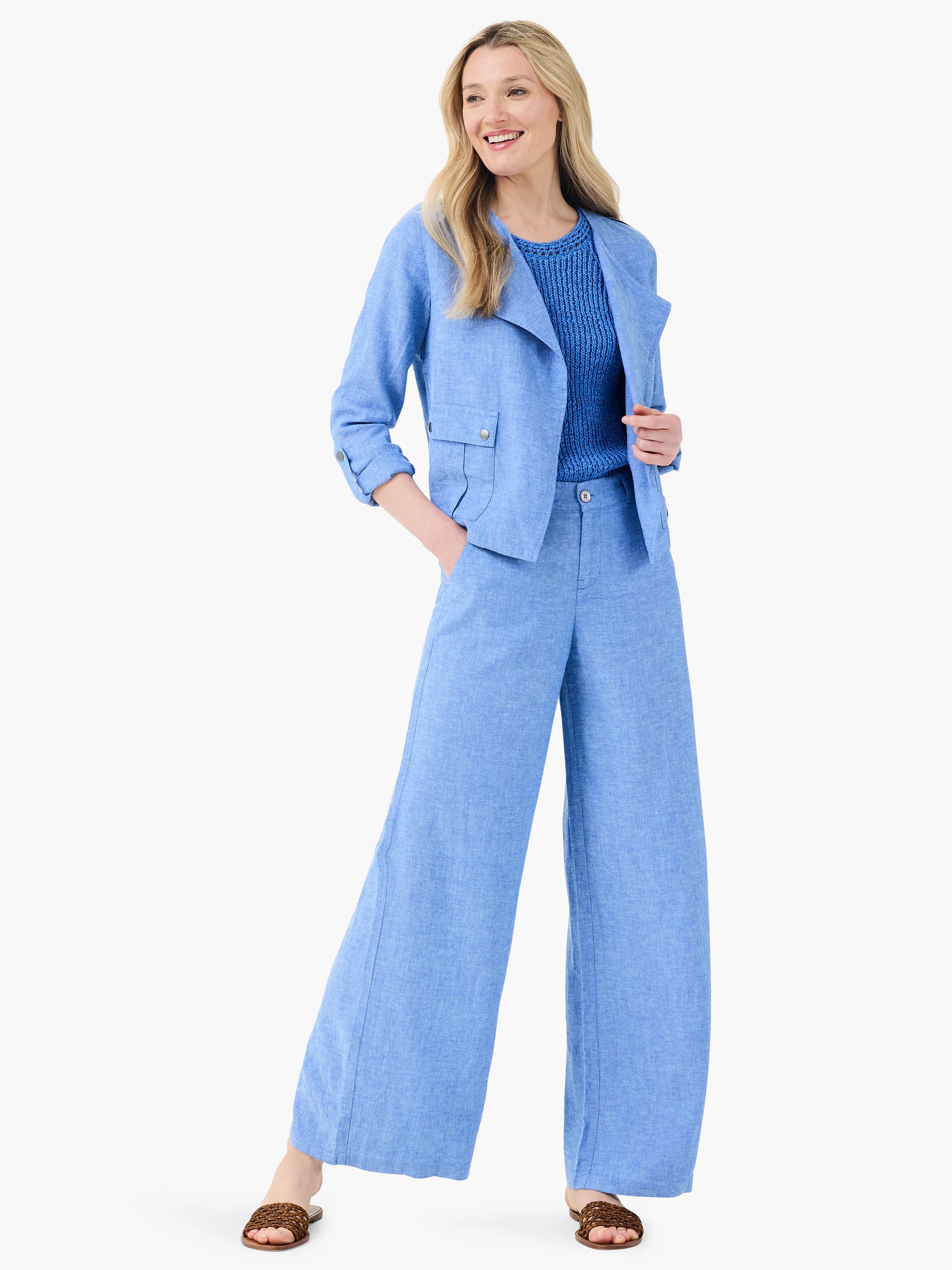 Periwinkle blue linen moto jacket, cropped, with notched lapels, snap flap pockets, and rolled sleeves.