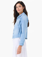 Light blue denim jacket with frayed hem and cuffs, shown on model.