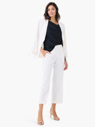 Off-white blazer with sleeves cuffed at the wrist, distinct lapels, and an open, relaxed fit.