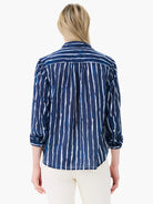 Back view of navy blue shirt with uneven white vertical watercolor stripes; sleeves rolled up.