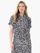 Button-up top in black, white, and grey abstract animal print, with short cuffed sleeves and an elasticated waist.