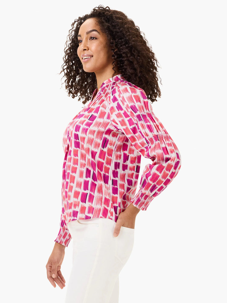 Pink, fuchsia, and purple brushstroke pattern blouse on white with a stand collar and smocked cuffs.