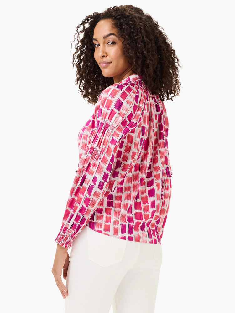 Pink, magenta, red brushstroke top with long sleeves, gathered mock neck, and smocked cuffs.