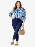 White top with abstract light and dark blue brushstroke pattern, split neckline, and elasticized cuffs.