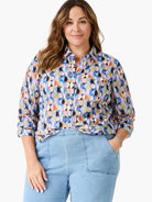 Multicolor button-up shirt with a vibrant geometric pattern of overlapping circles in various shades. Sleeves rolled.