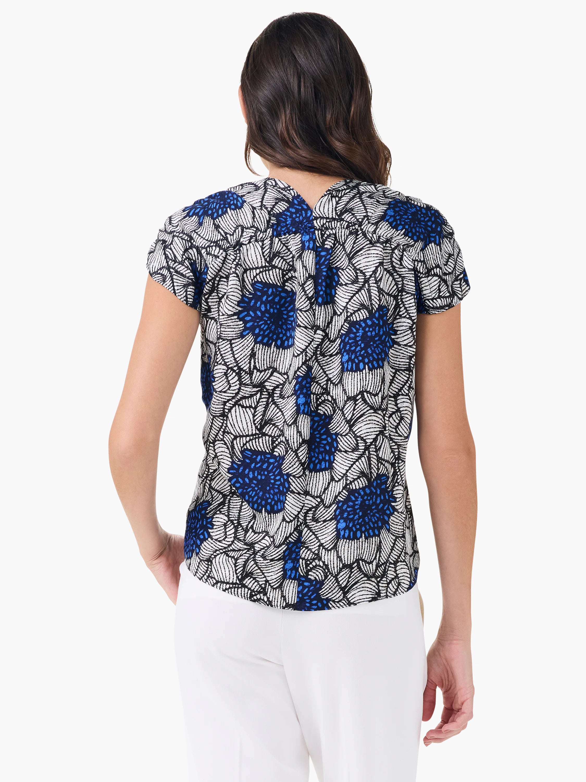 Back of Petal Bloom Top: blue, white & black floral print, short sleeves, gathered upper back.