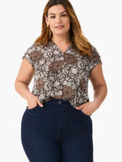 Short-sleeve, V-neck top with an abstract floral pattern in dark brown, tan, and cream.