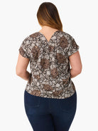 Back view: Petal Bloom Top with brown and cream abstract petal pattern, V-neck back, short sleeves.