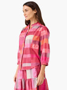 Plaid shirt in shades of pink, orange, cream, and purple. Features a ruffled collar and gathered 3/4 sleeves.