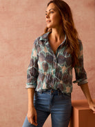 Crinkled button-down shirt with a mottled teal, dark gray, and pale beige pattern. Sleeves rolled.