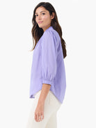 Lavender cotton shirt with a ruffled neckline, 3/4 gathered sleeves, and smocked cuffs.
