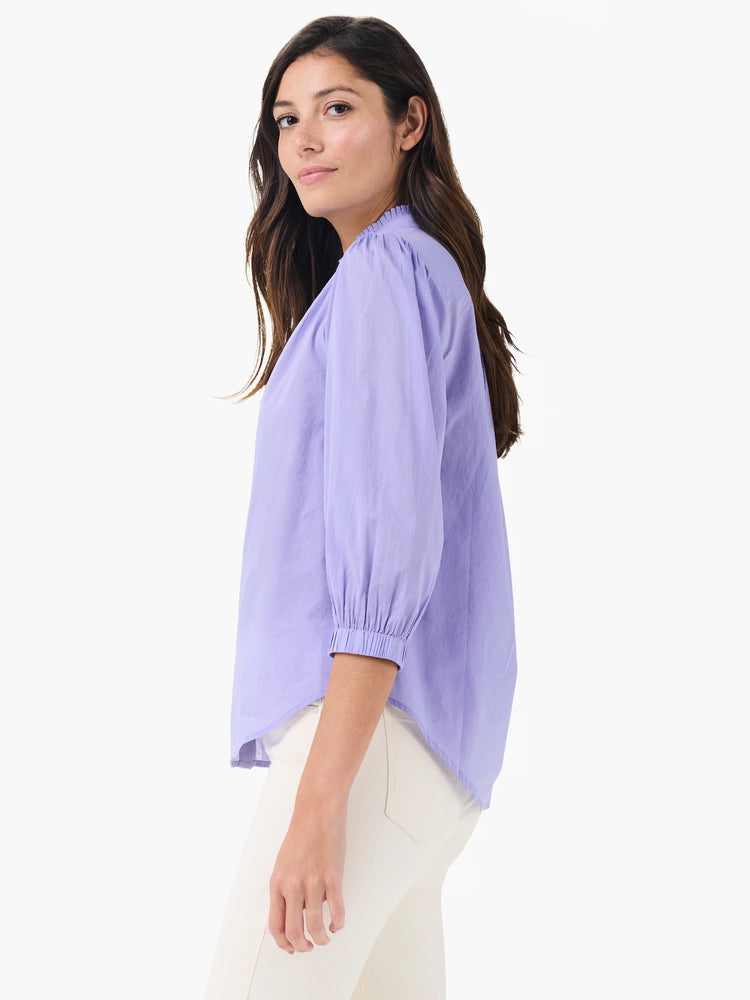 Lavender cotton shirt with a ruffled neckline, 3/4 gathered sleeves, and smocked cuffs.
