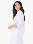 White cotton shirt with a ruffled collar, gathered 3/4 sleeves with elasticized cuffs, and a relaxed silhouette.