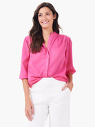 A bright pink cotton shirt with a band collar, partial button-front, and 3/4 sleeves.
