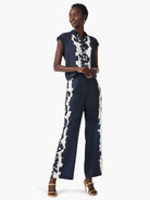 Rose Bloom Top: Navy blue sleeveless, collared top with a bold, vertical white abstract pattern.