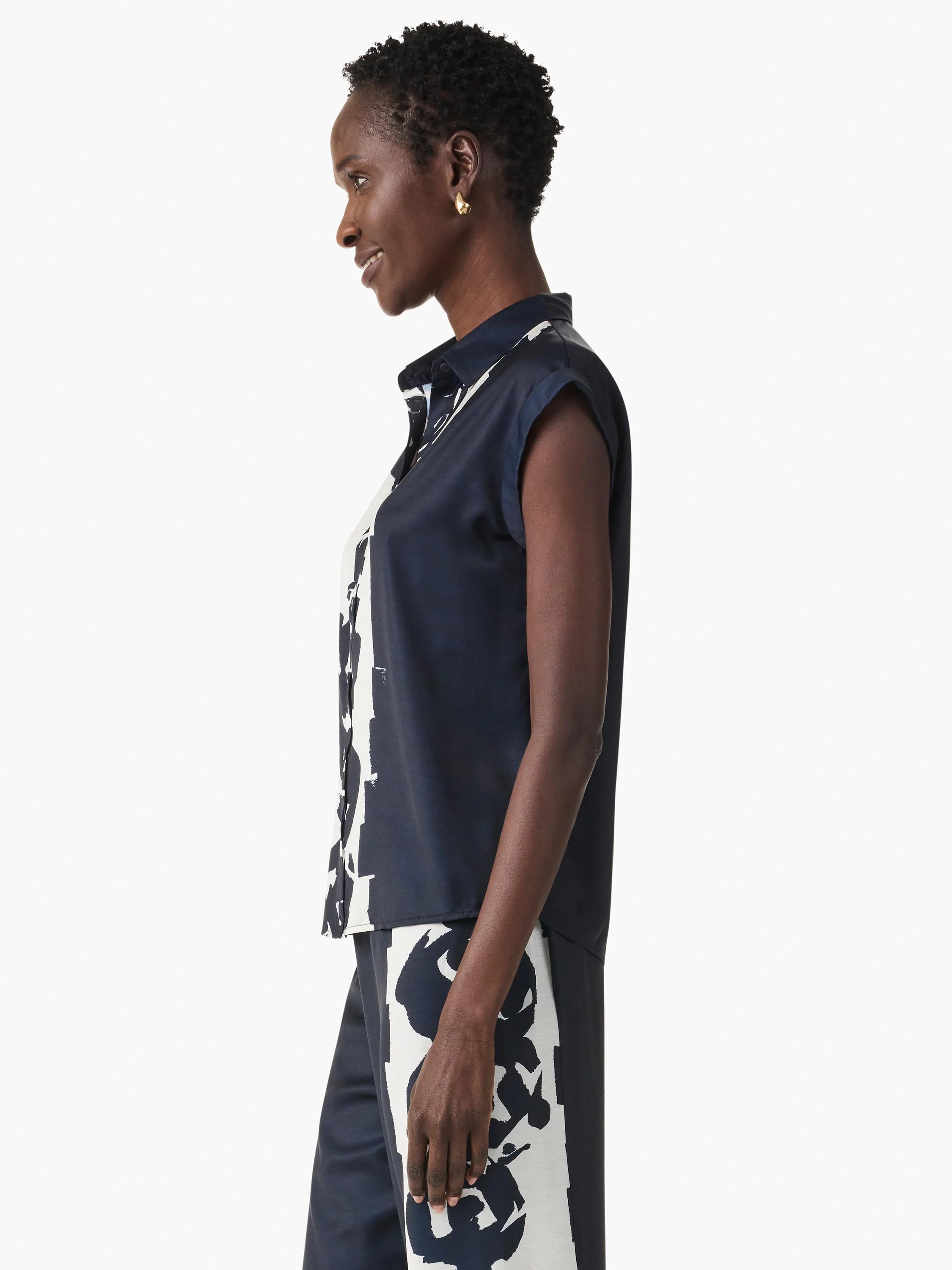 Navy collared top with cap sleeves and white abstract pattern on the button-front placket.