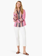 Pink long-sleeve top with vertical navy and peach dotted stripes, button-front closure.