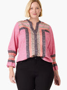 Pink top with navy, peach, & cream striped & dotted patterns on body, placket, & smocked cuffs.