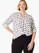 White button-down shirt with grey-brown clover stamp pattern, V-neck, chest pockets, and rolled 3/4 sleeves.