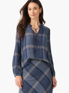 Navy blue and beige plaid long-sleeve blouse with a drawstring neckline.  The blouse is shown with a matching skirt.