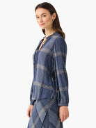 Navy blue and beige plaid long-sleeve top with a ruffled neckline and drawstring.