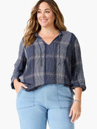 Navy blue and white plaid top with a V-neck and drawstring detail.  Long sleeves.