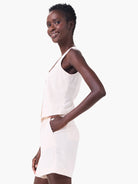 Off-white linen vest and shorts; sleeveless, cropped vest.