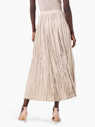 Pale beige long skirt with a crinkled, crushed texture and vertical pleats. Back view.