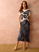 Midi-length wrap skirt in blue, beige, and white plaid.