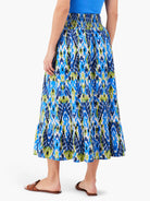 Midi-length skirt with an elastic waistband. Blue, green, and white abstract print.  Features a tiered ruffle hem.