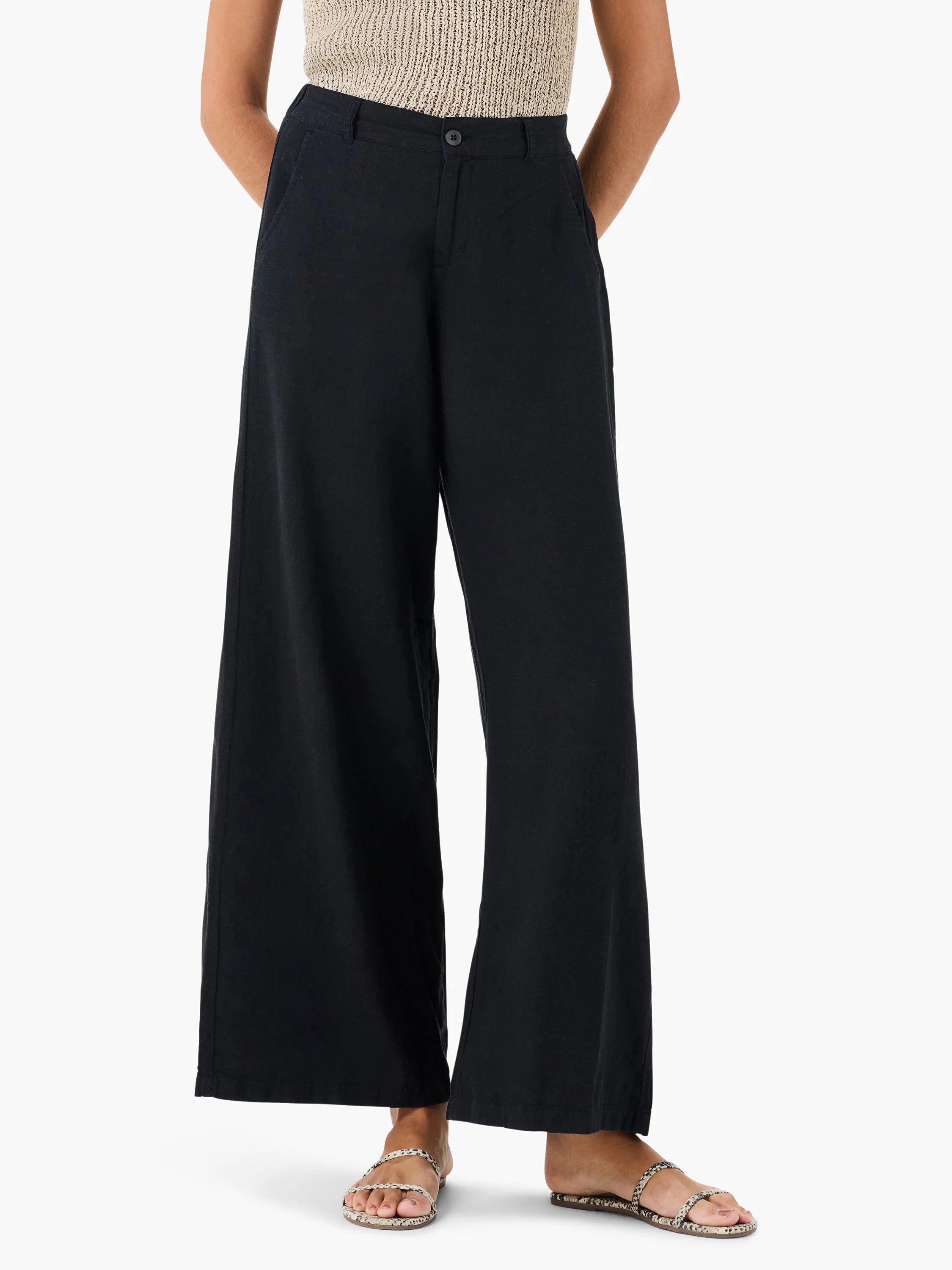 Black wide-leg linen trousers;  model wears beige top and snakeskin sandals.