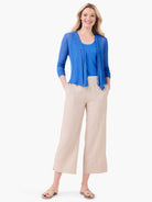 Light beige wide-leg crop pants featuring front seams and a textured, relaxed fit.