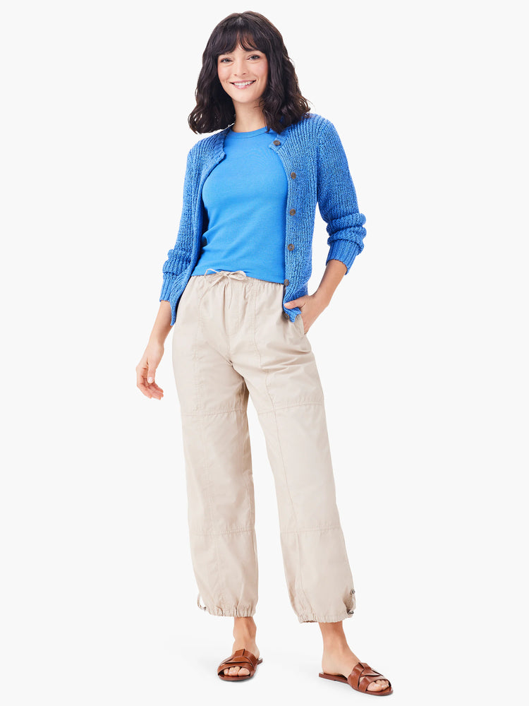 Beige ankle-length pants with drawstring cuffs.  Model wears blue top & cardigan.