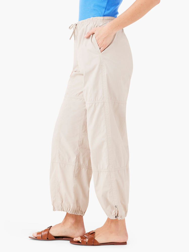 Beige ankle-length pants with drawstring waist and cuffs.  Multiple stitched panels.