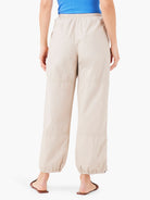 Beige ankle-length pants with elastic cuffs and subtle stitching details.  Rear view.