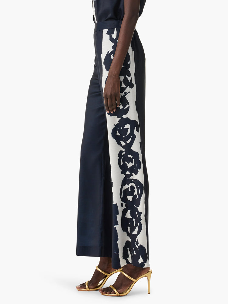 Navy blue wide-leg pants; off-white side panel with dark brushstroke rose design.
