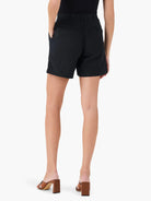 Black linen shorts, mid-thigh length, elasticized waist, pockets.  Rear view.