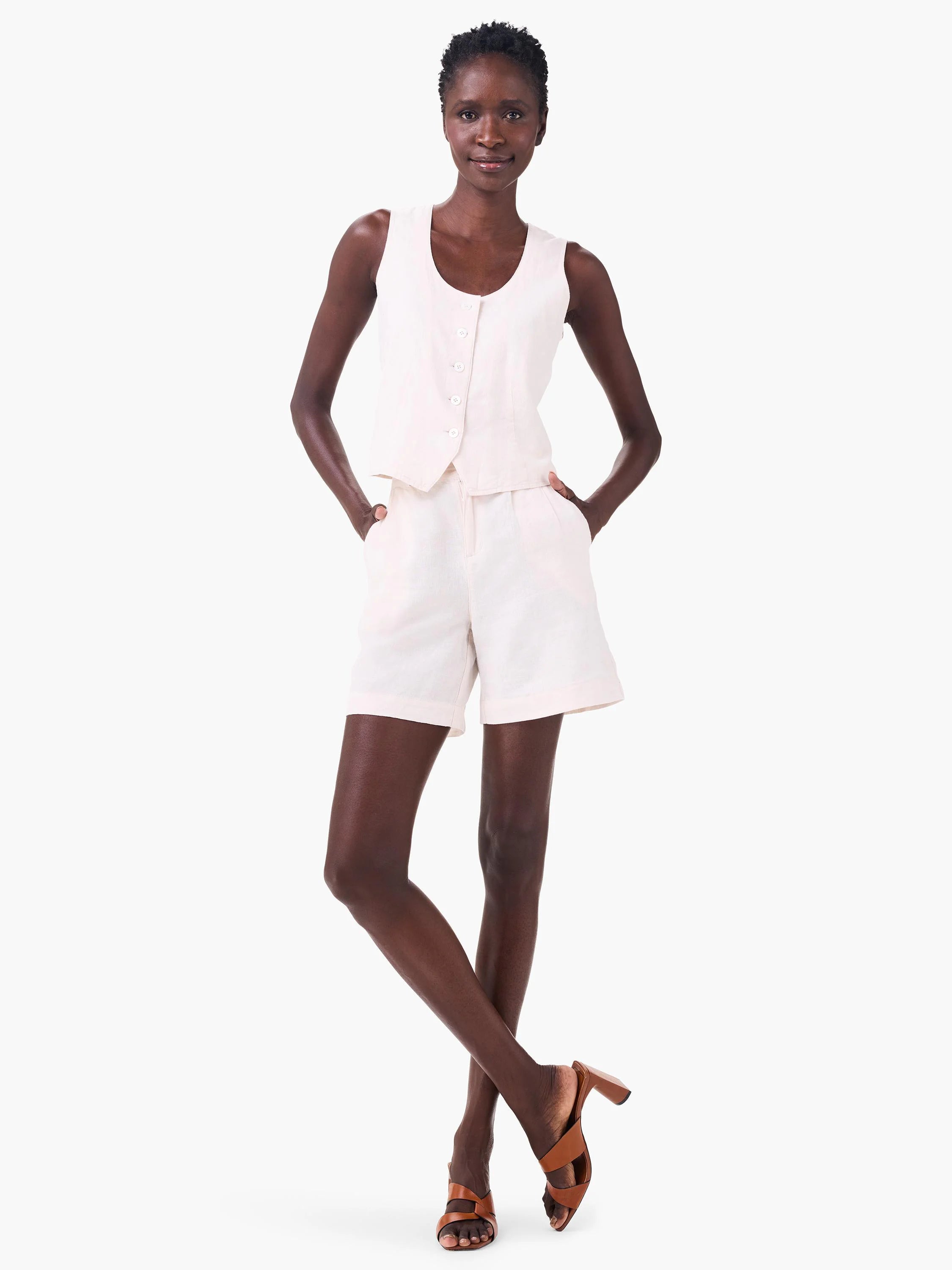 Off-white linen shorts and matching sleeveless top on a model.  Brown heels are also visible.