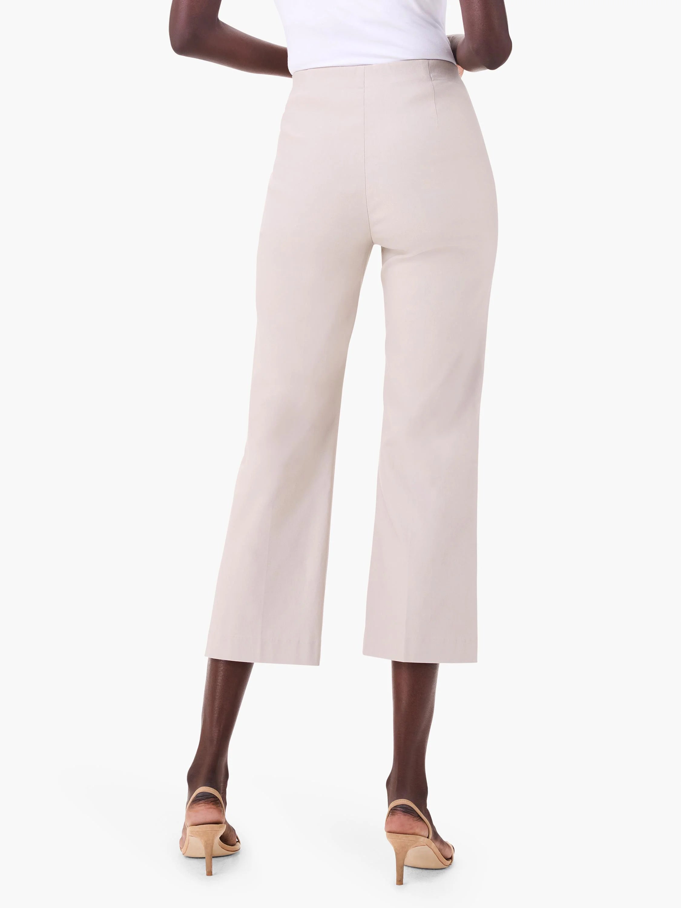 Light beige wide-leg crop pants on a model, seen from behind. Smooth fabric, ends above the ankle.